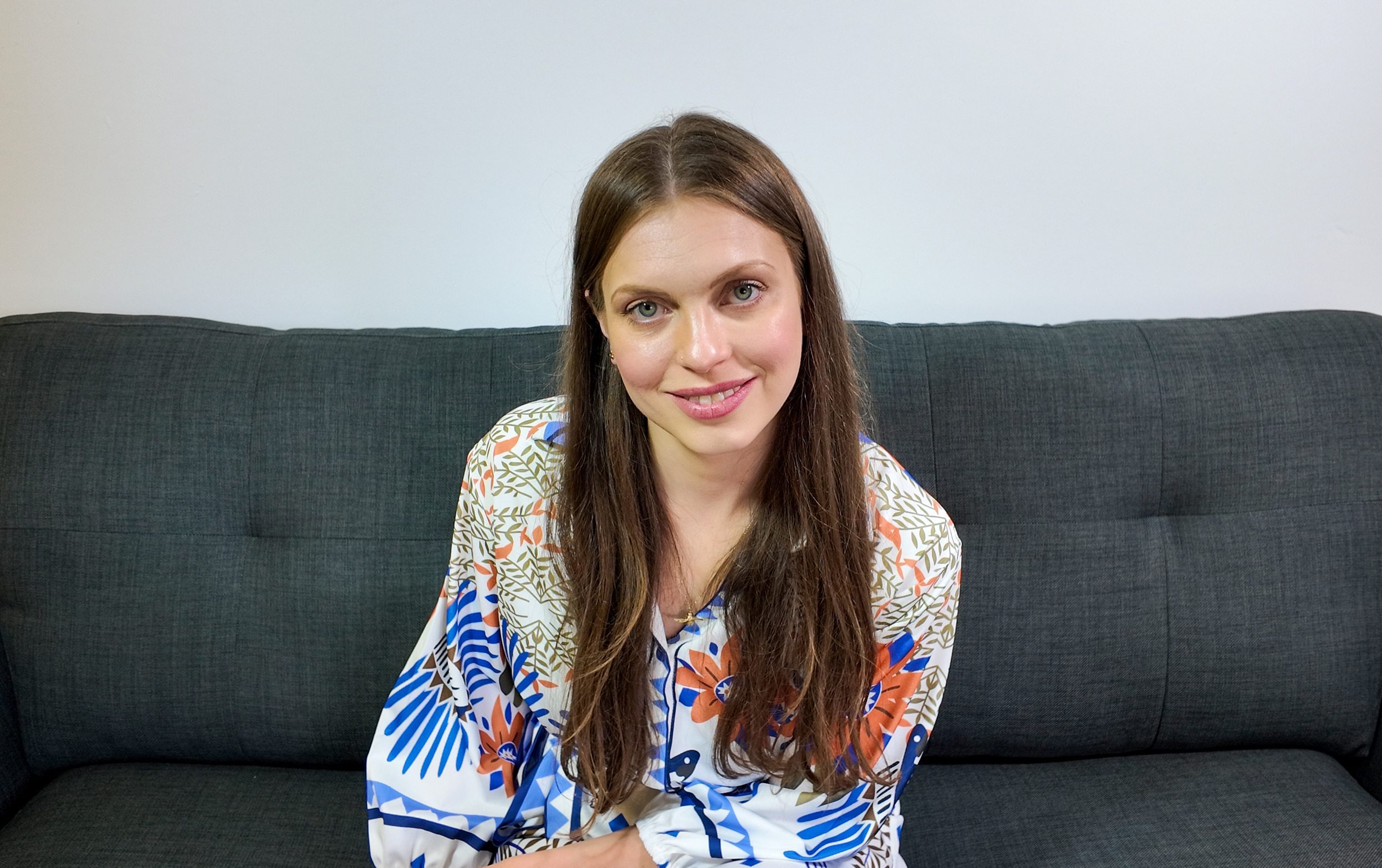Megan Baldry, Perinatal Counsellor and Psychotherapist, on sofa in a patterned dress