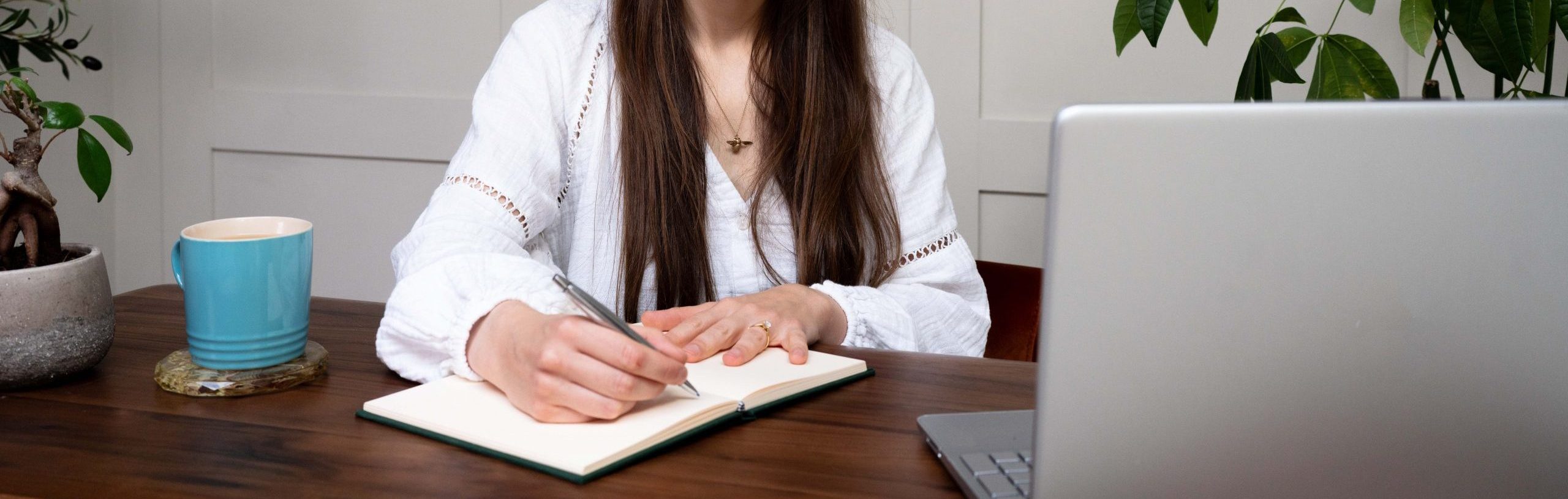 Megan writing in a notebook at a desk.
