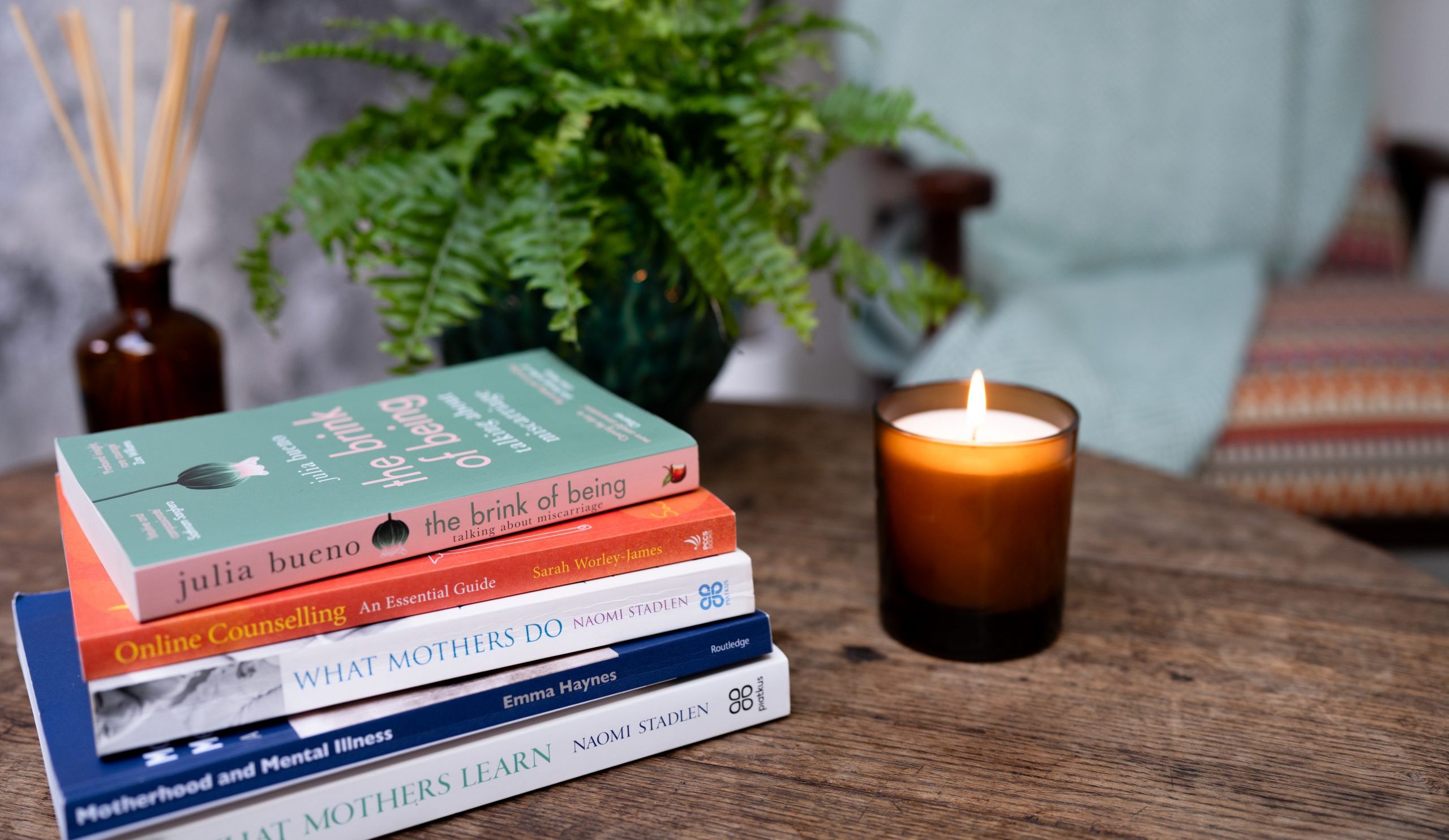 Books (related to perinatal mental health) next to a candle