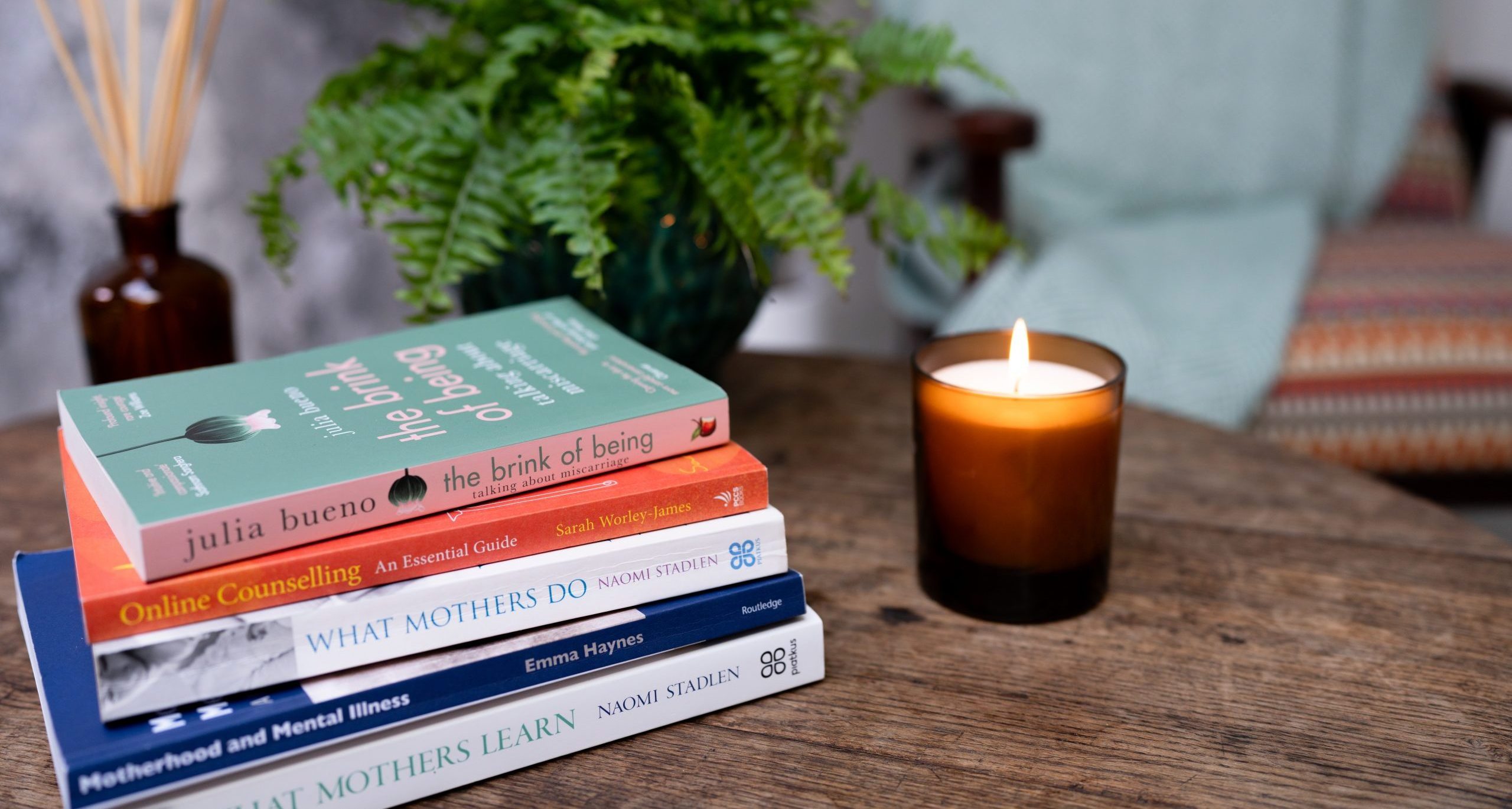 Books (related to perinatal mental health) next to a candle